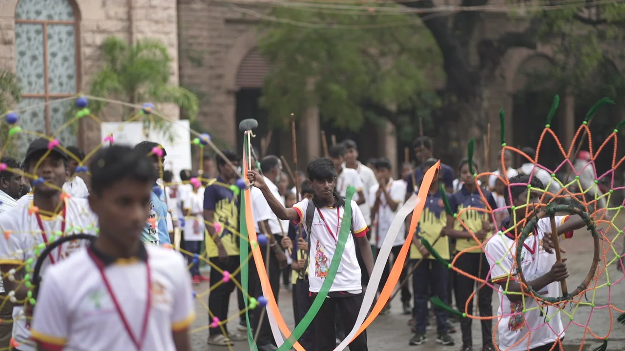 Students carrying colourful traditional procession decorations
