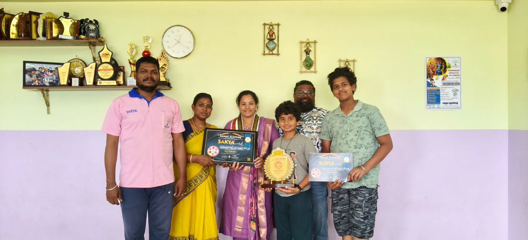 Group holding award certificates and a trophy